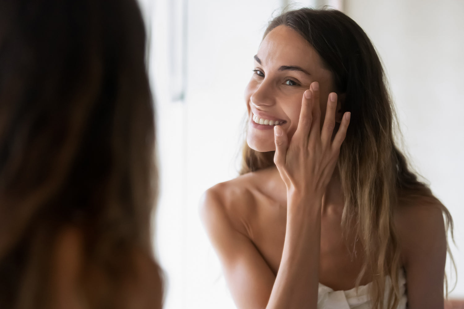 Frau, die zufrieden mit ihrem Spiegelbild ist