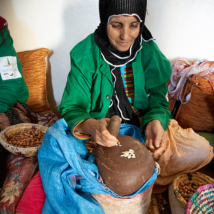 Marokkanische Frau, die Argannüsse verarbeitet